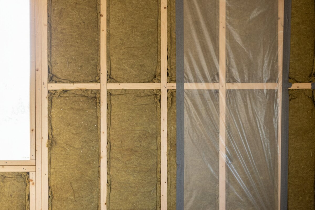 Houten wandframe met minerale wol tussen de stijlen en folie erover.